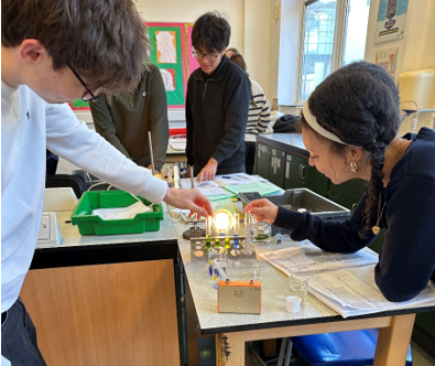 A group of people in a science lab classroom completing an experiment
