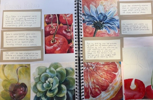 A photograph of an open sketchbook displaying detailed watercolor paintings of fruits and flowers, including a red apple, grapefruit, blue flower, succulent, and cherries. The pages feature handwritten notes on beige paper alongside each painting, providing observations and artistic insights, with the right page titled "Colour Factor."