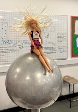 a toy doll on  a  Van de Graaff generator 