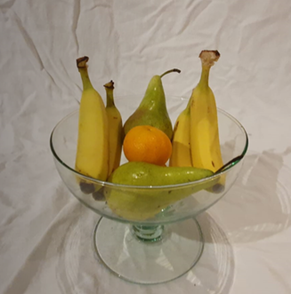 A bowl of fruit on a white surface