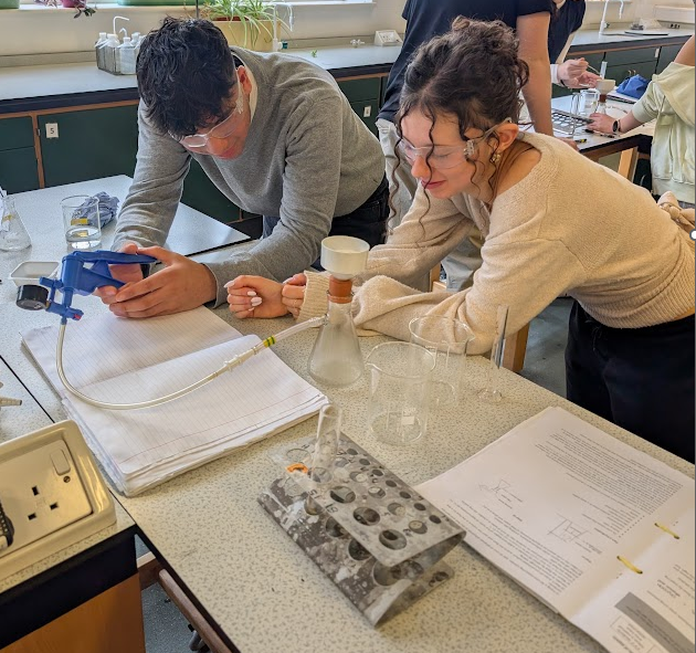 two students in a lab completing an experiment
