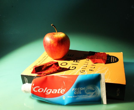 An apple and toothpaste on a book