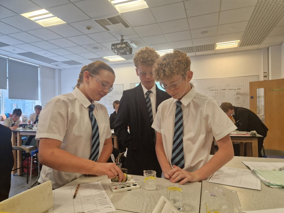 three students in a school science lesson