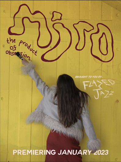 A person painting a sign on a yellow wall