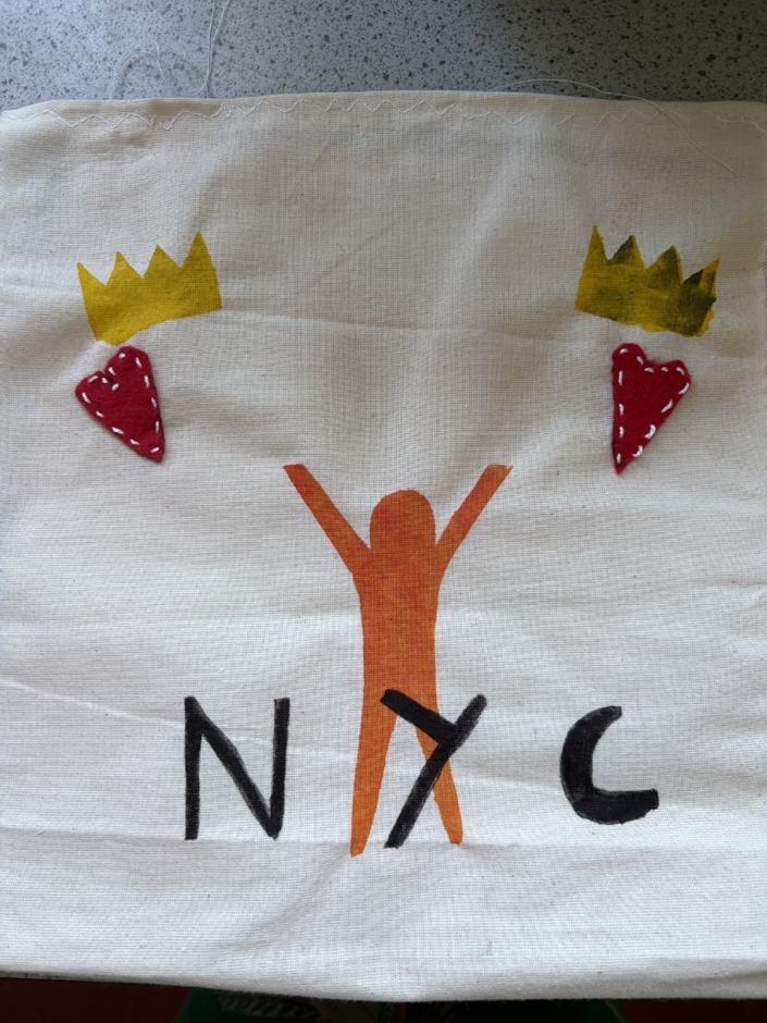 A white fabric with a tree and crown and NYC