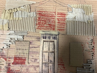 A cardboard wall with a window and a door