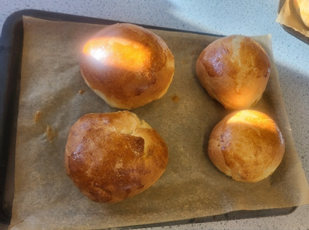 A group of four bread  rolls on a tray