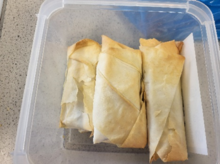 a box with three spring rolls in