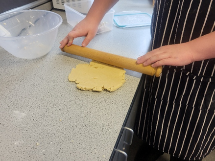 A person rolling out dough on a counter