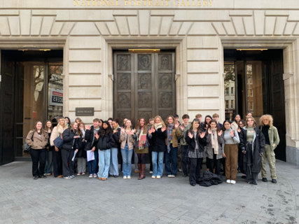 a group of students standing put side a museum