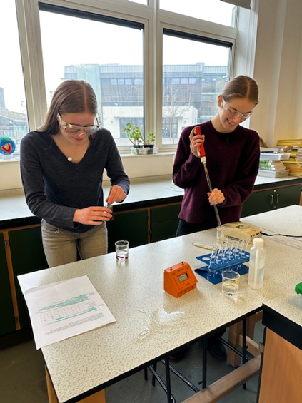 Two students in a lab investigating the factors that influence the permeability of cell membranes 