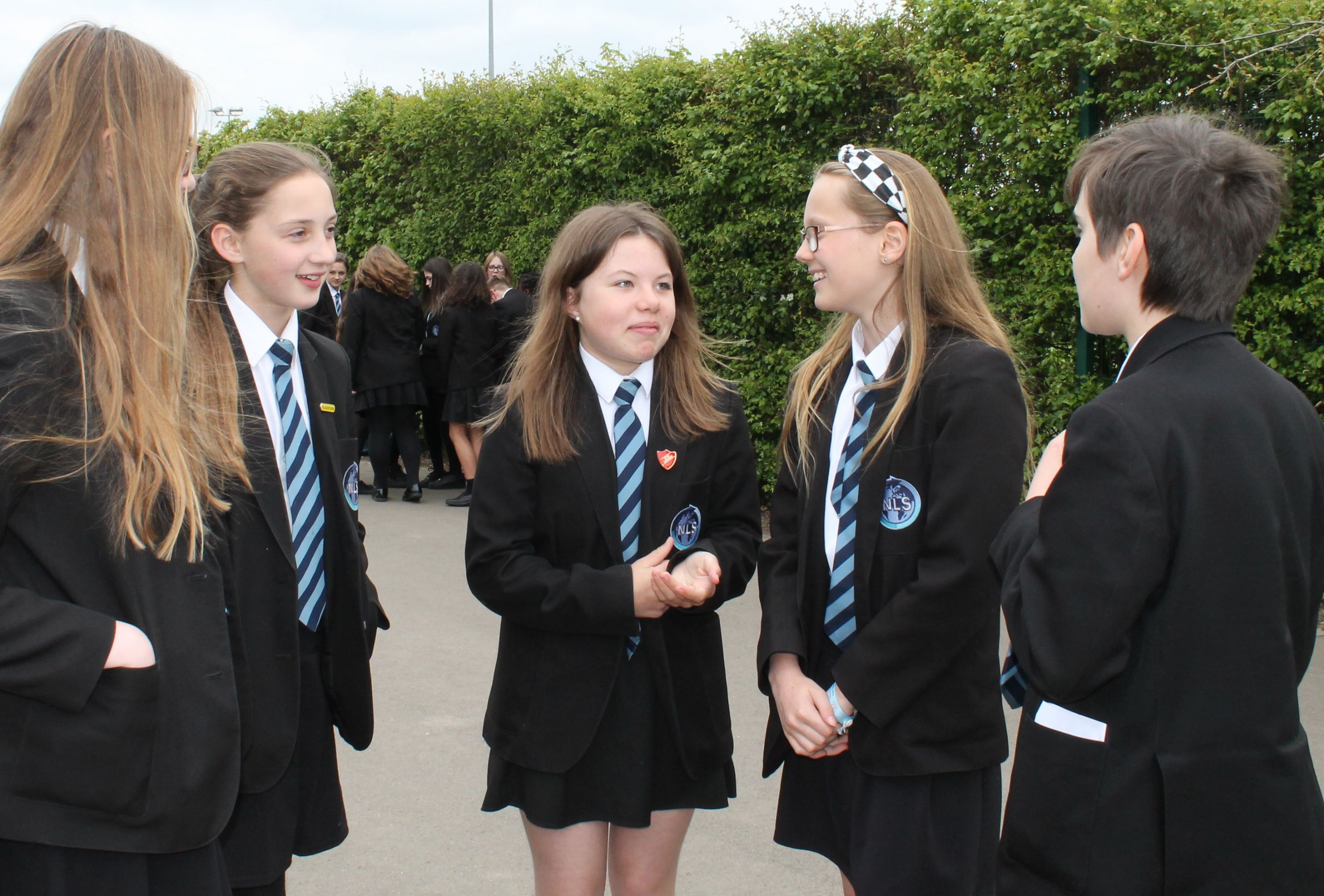 Five students chatting in the playground area 