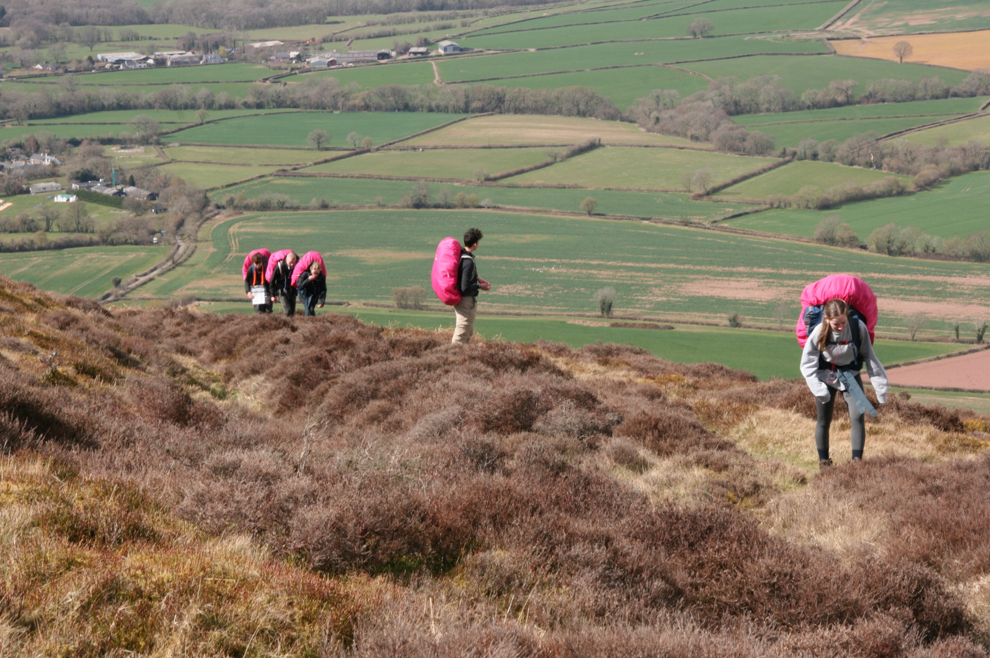 five students hiking with pink backpacks
