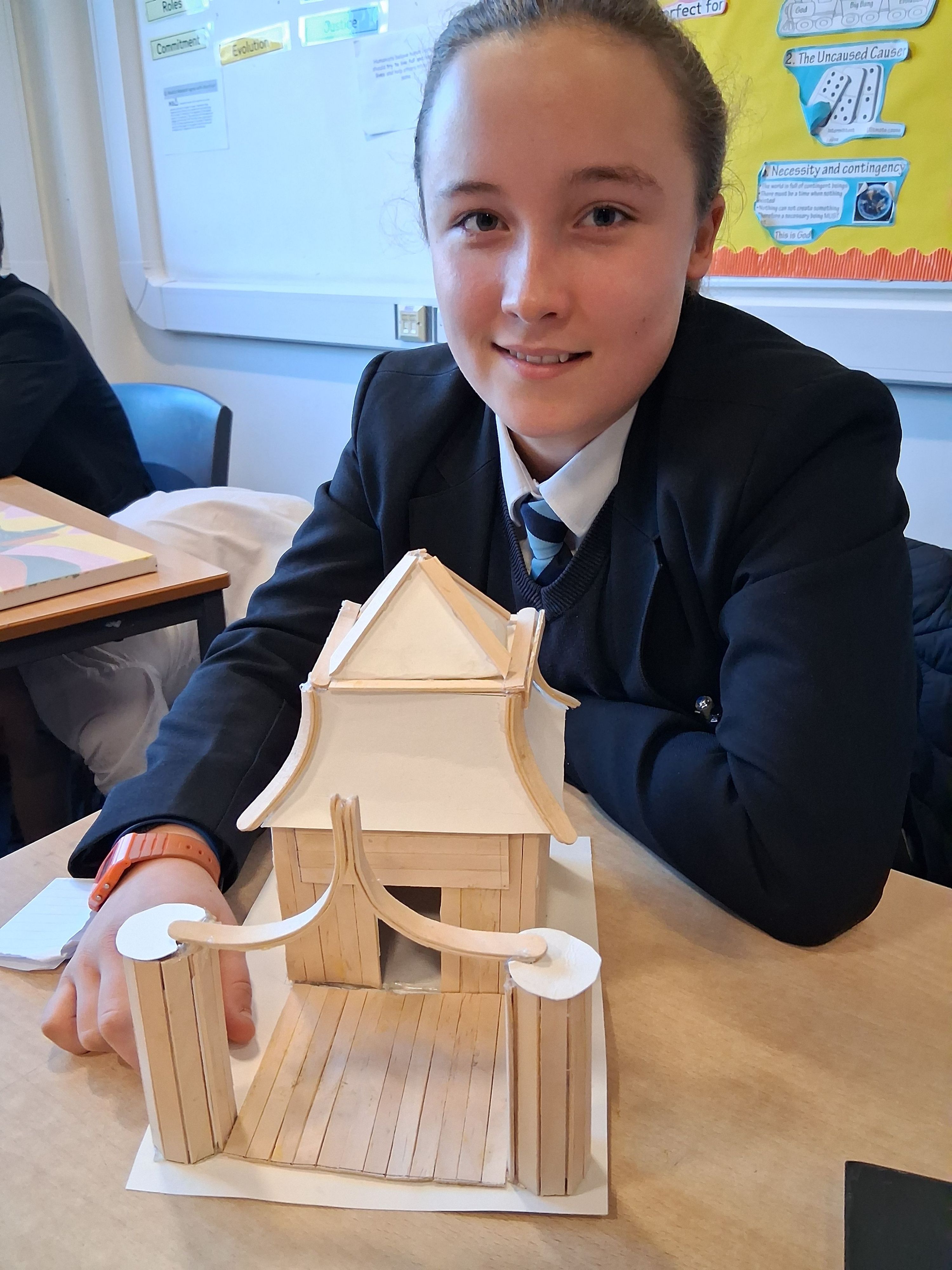 a student with a buddhism tpwer made from paper 