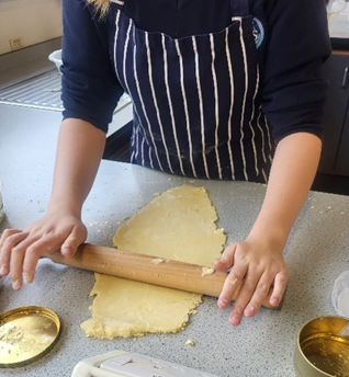 A person rolling out dough on a counter
