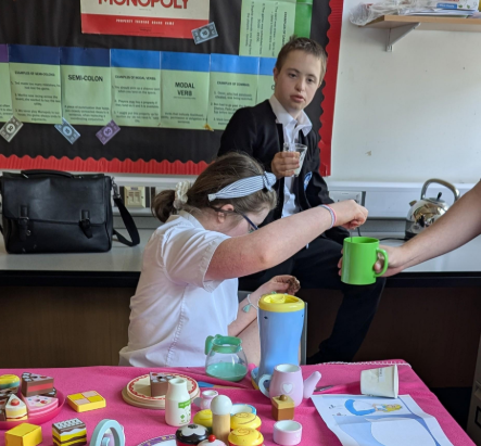two students themed work for a tea party studying Alice in Wonderland  