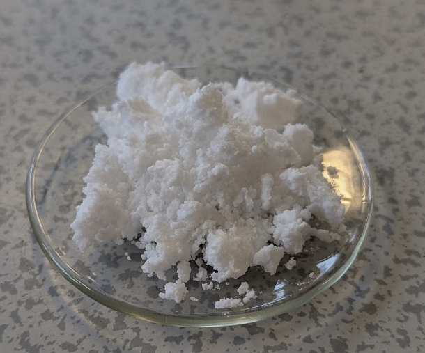 a white powder - aspirin - on a clear glass dish