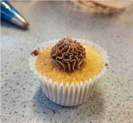A cupcake with piped icing on a counter