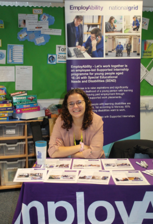 a person sitting a stand at the careers fair