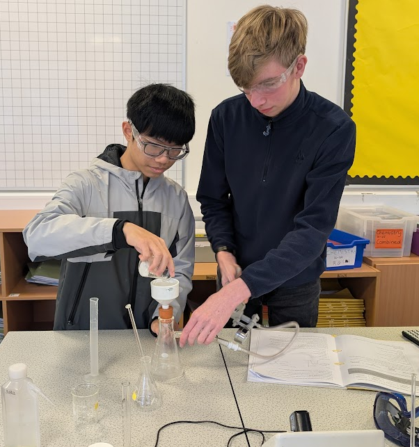 two students in a lab completing an experiment