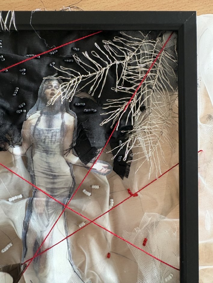 A black framed picture of a person in a dress