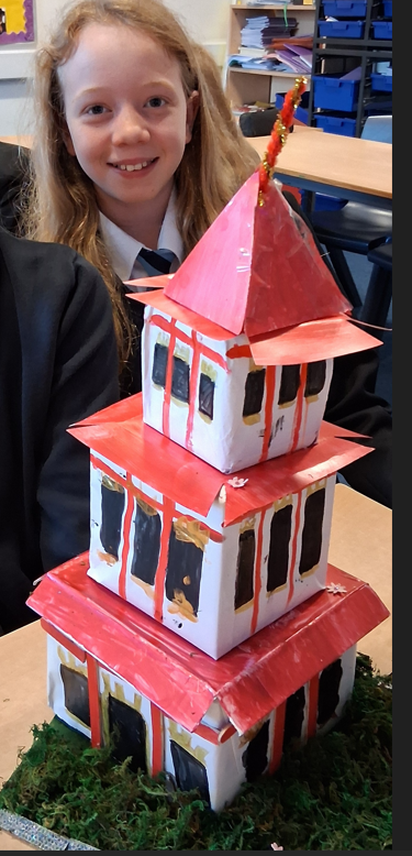 a student with a a buddhism tpwer made from paper