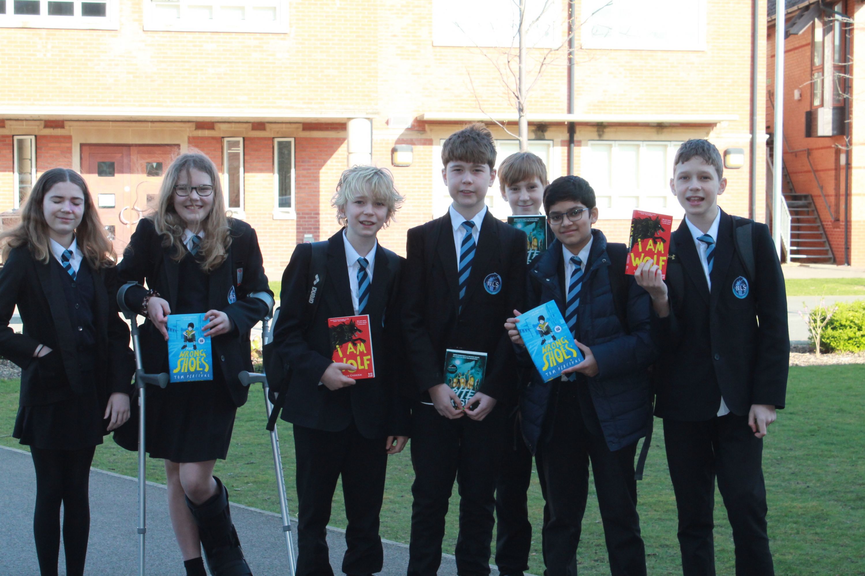 seven NLS students holding books at the Warwickshire Book Award Ceremony