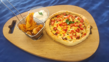 A pizza and potato wedges on a wooden tray