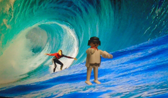 A toy figurine of a person surfing in a wave