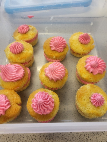 A tray of cupcakes with pink frosting