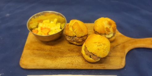  three  burgers on a wooden surface