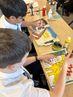 two students  painting on paper
