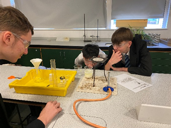 A group of people looking at a yellow container