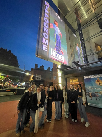 a group of students standing outside the Hippodrome by a  sign displaying the show Hidden