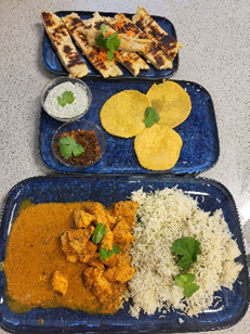 a dish of rolled chapatis, a dish of three mini popodoms and  a dish of curry and rice
