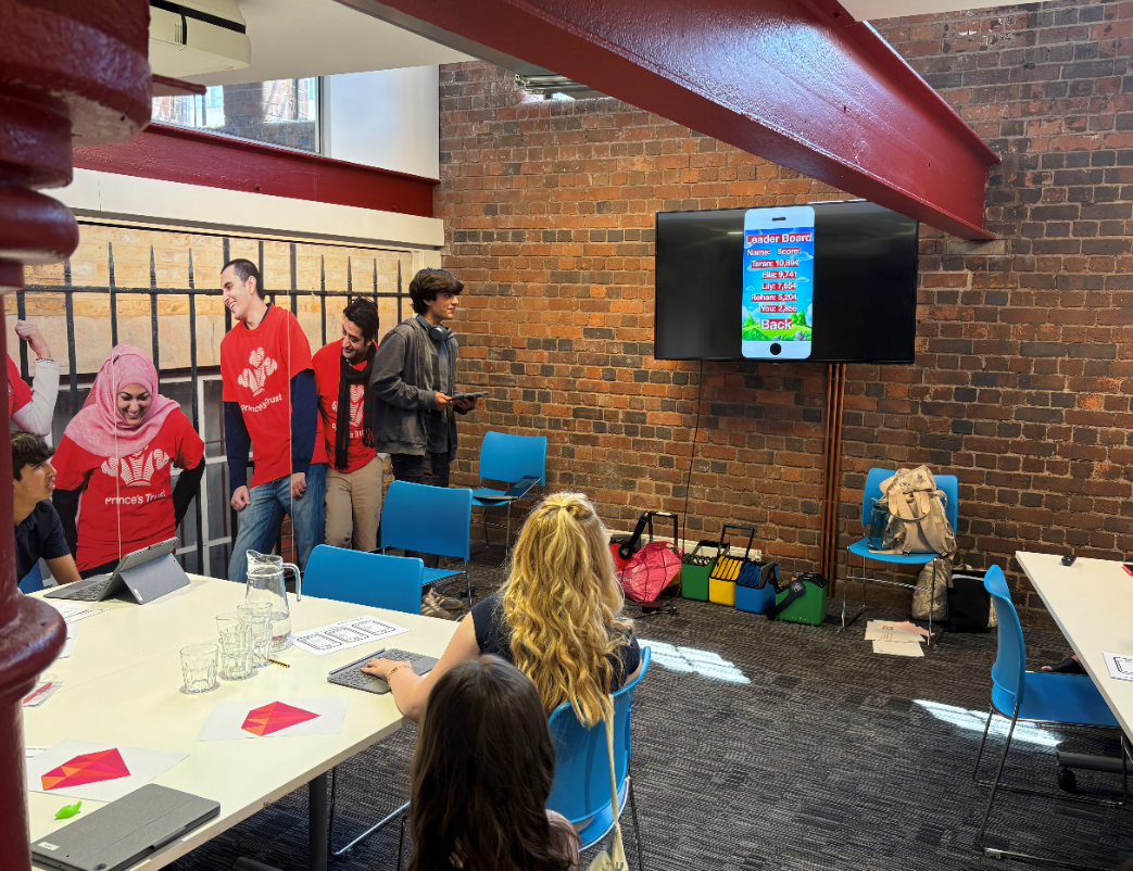 A PRESENTER PRESENTING TO TWO STUDENTS AT THE APPLE WORKSHOP