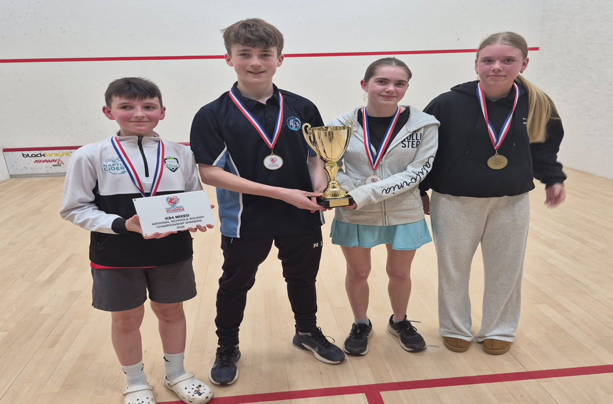 FOUR STUDENTS HOLDING A TROPHY