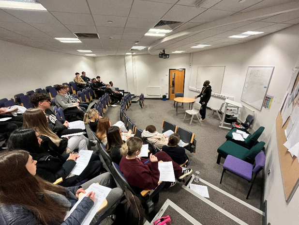 A group of people in a classroom / lecture theatre 