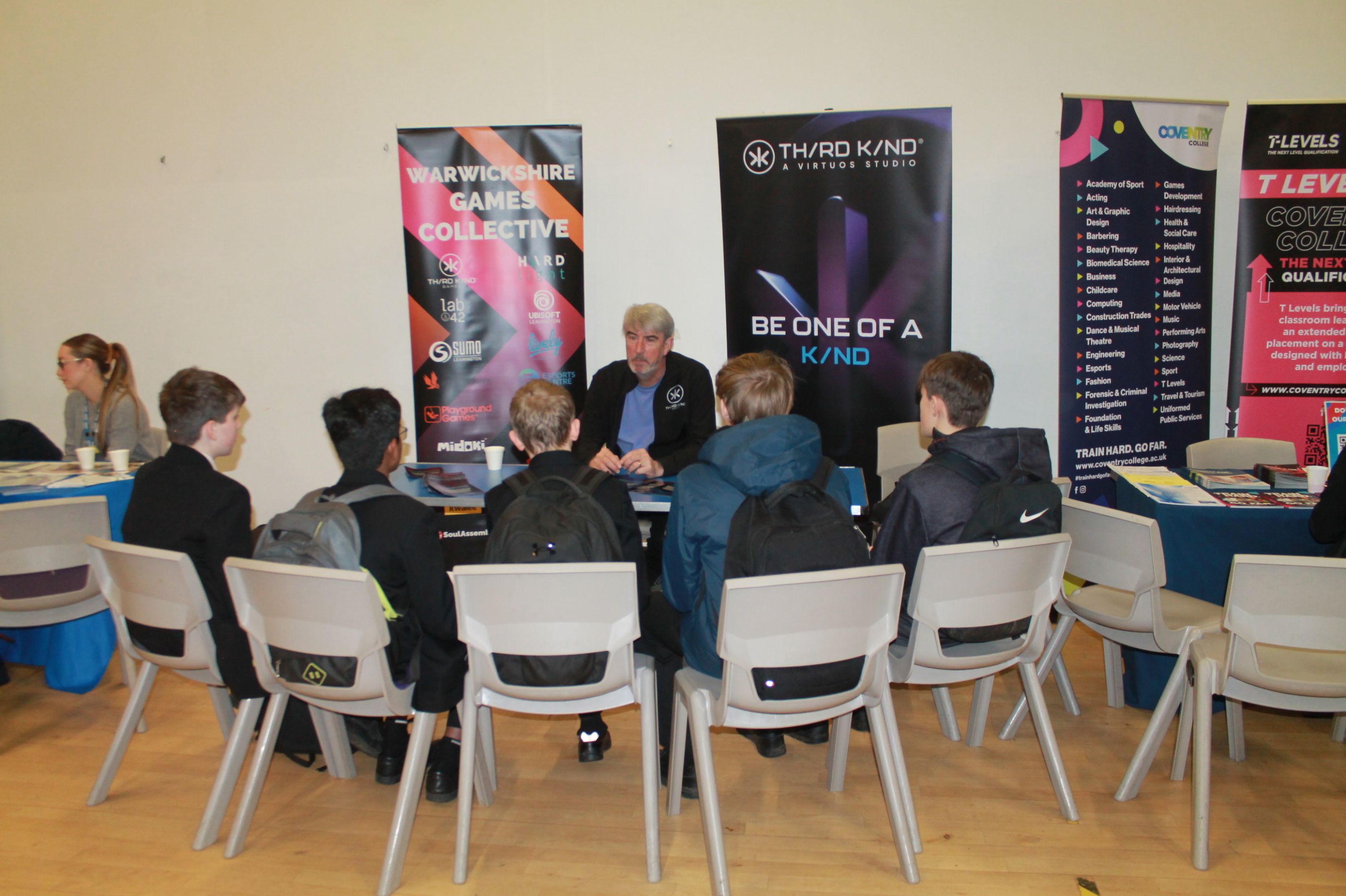A group of five students  sitting at a table