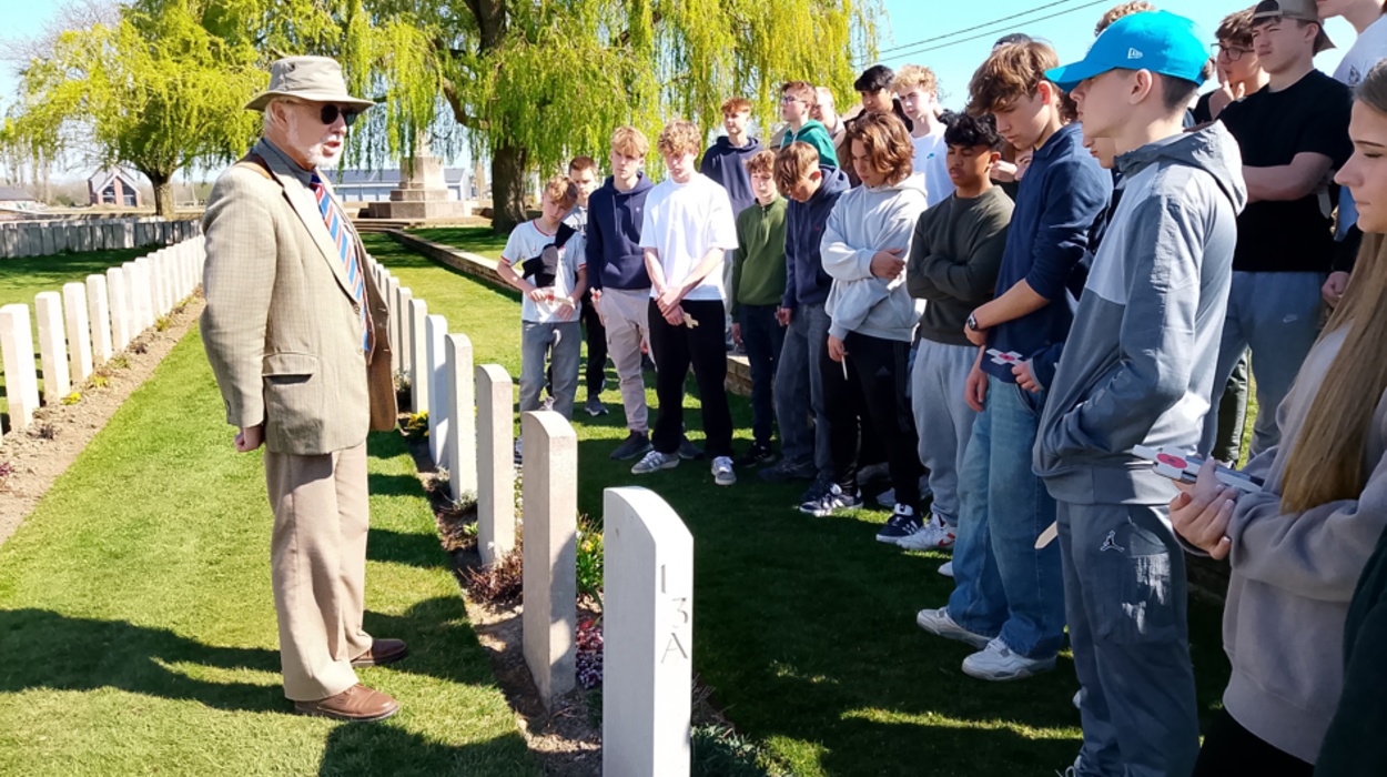 students listening to theguide at  Lijssenthoek Military Cemetery,