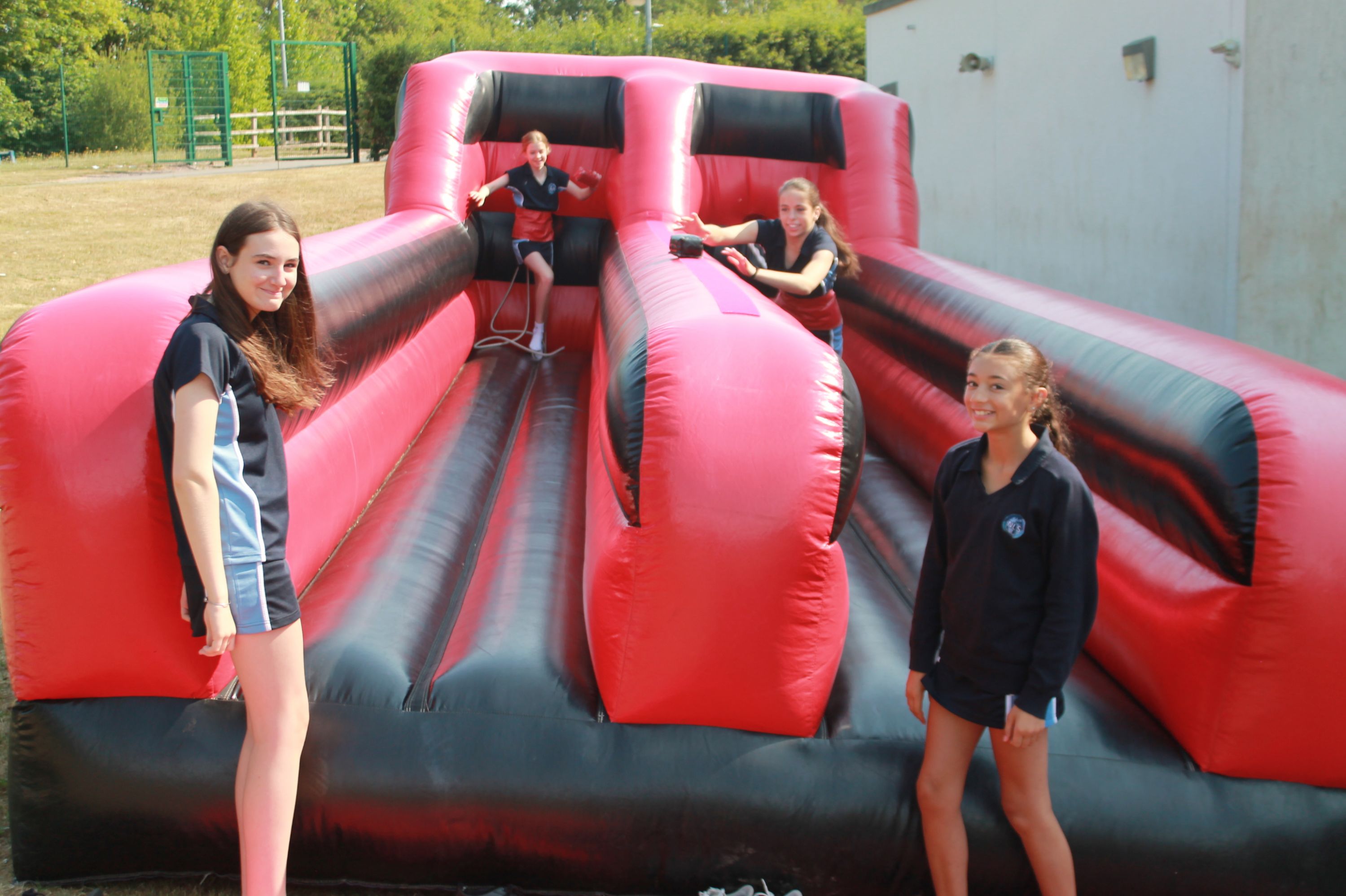 four students enjoying the inflatable runner