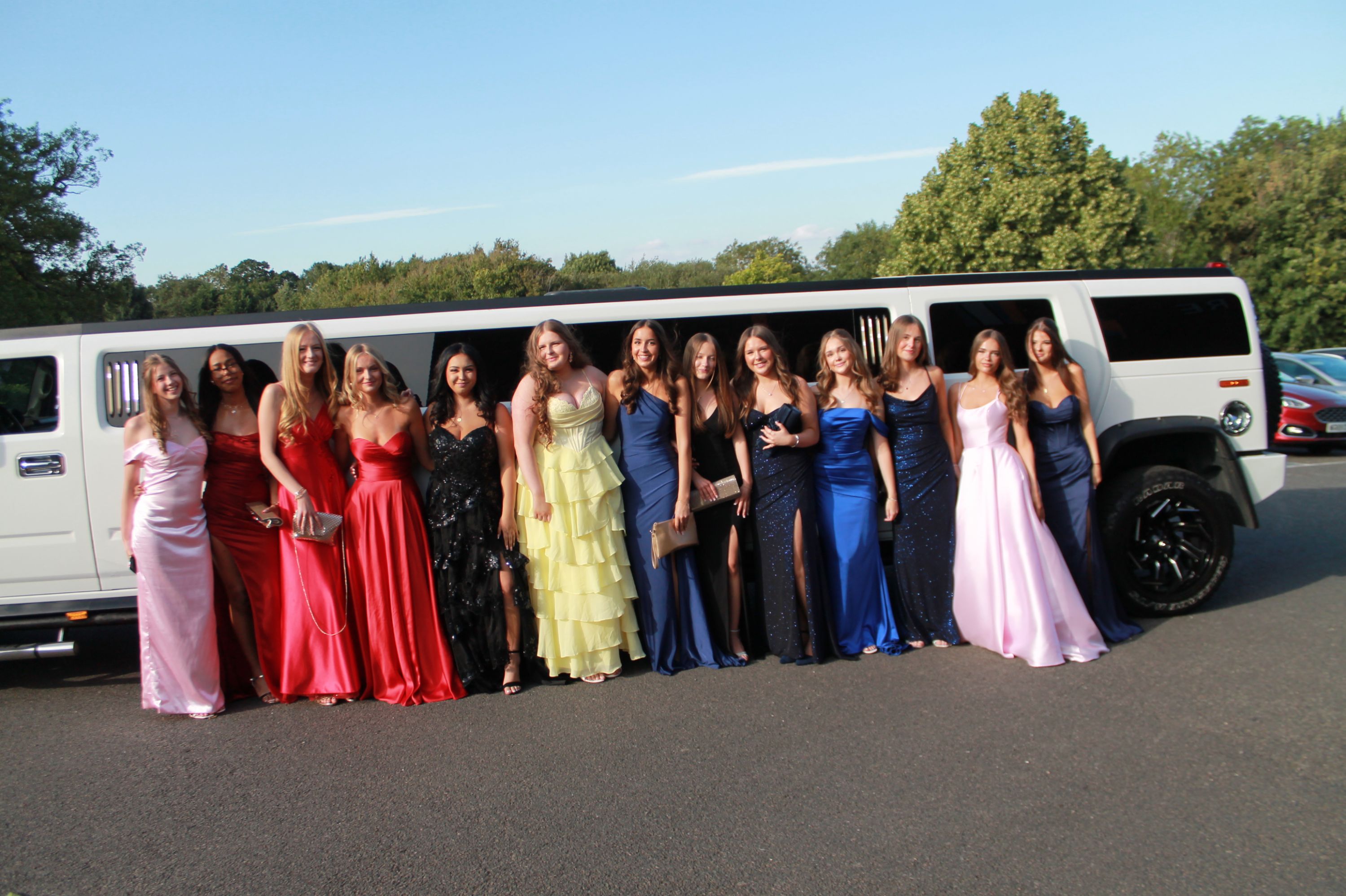 13 studnets by the side of a limo arriving at prom