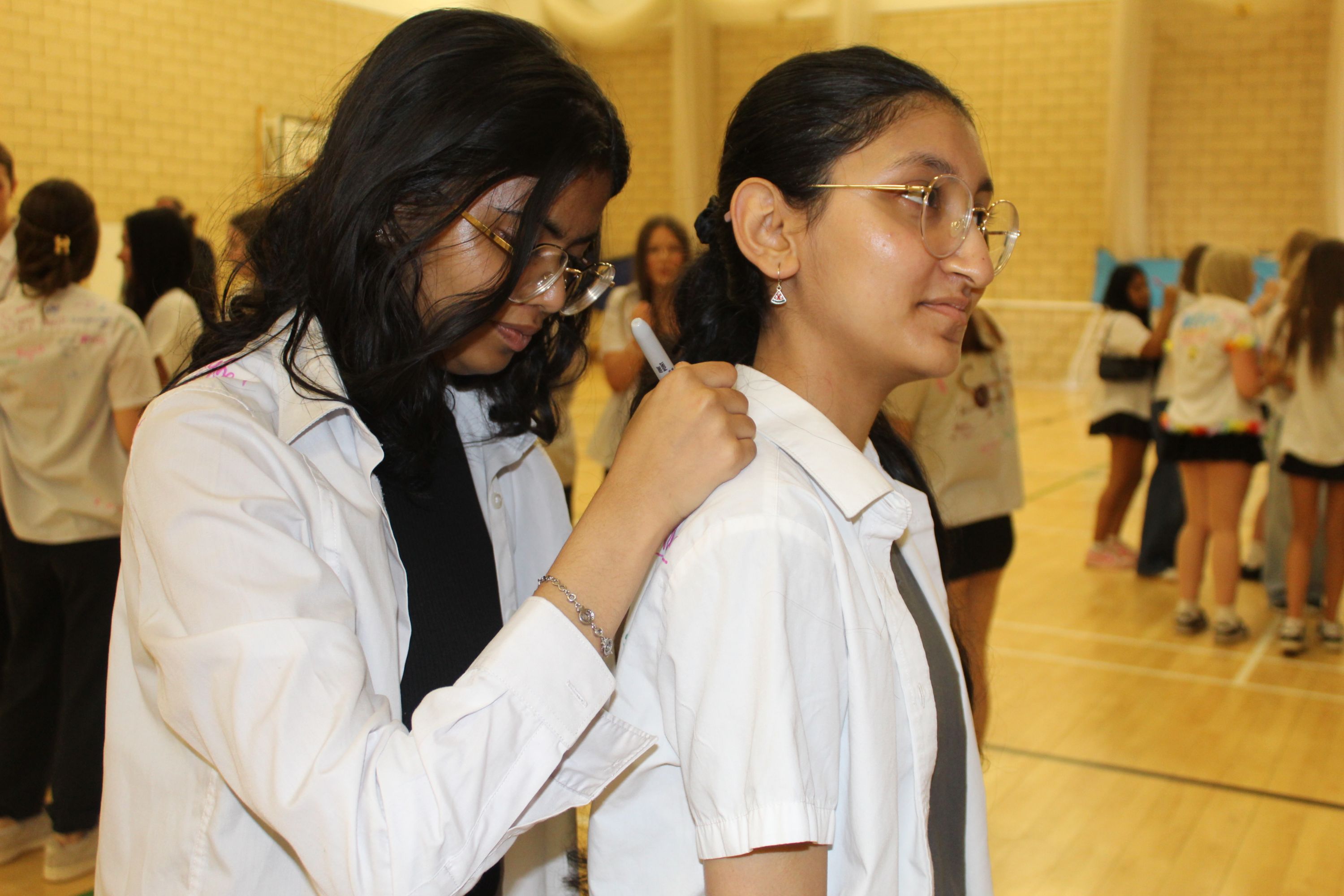 One student signing another's shirt at the Celebration day 