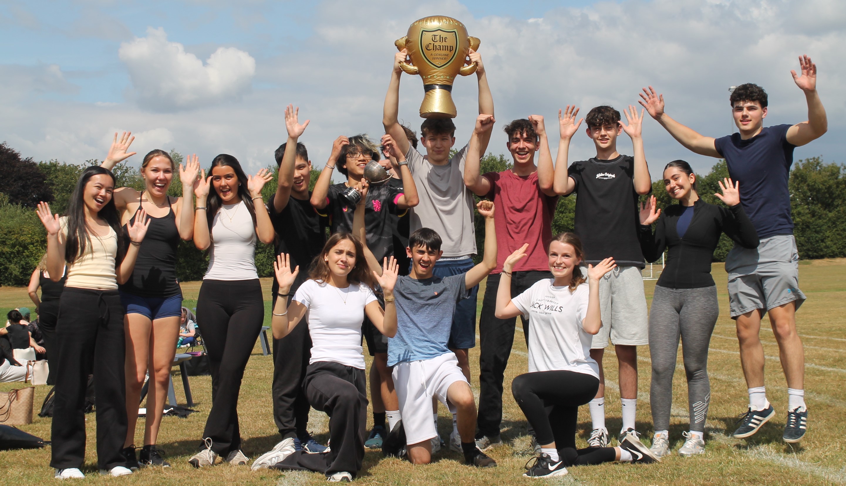 a group of students holding the trophy for winning sports day