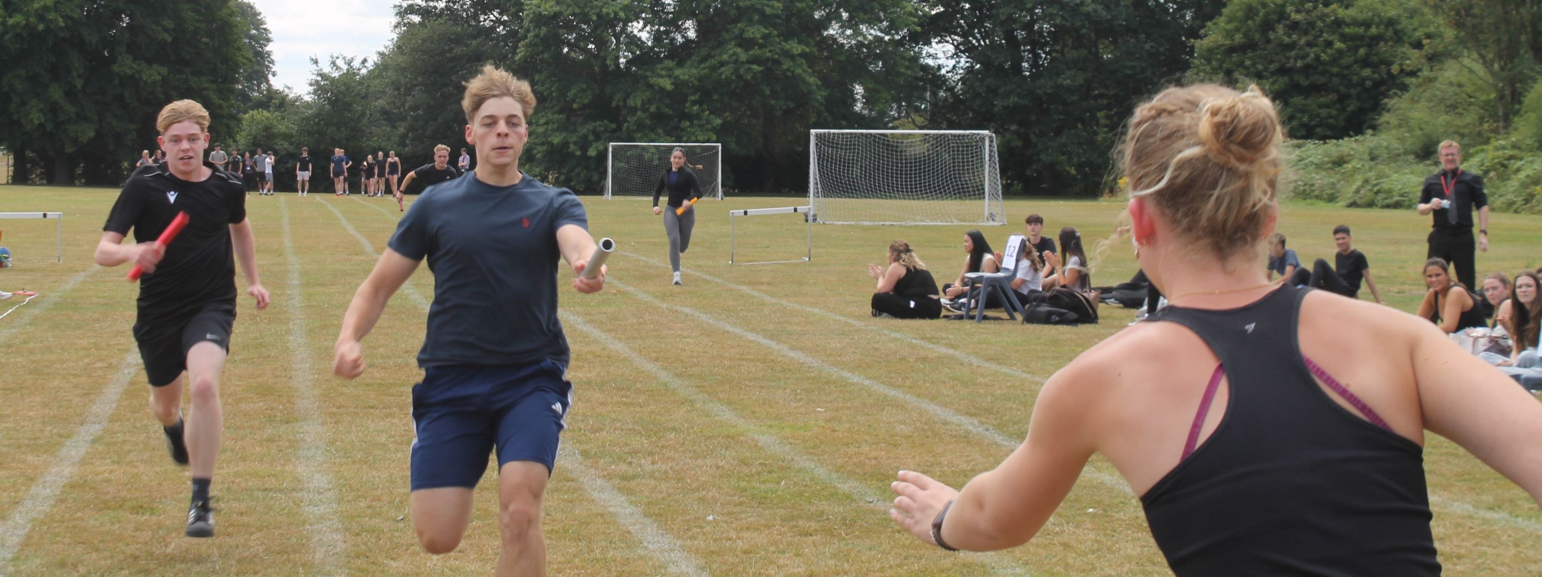 three students running in a relay race