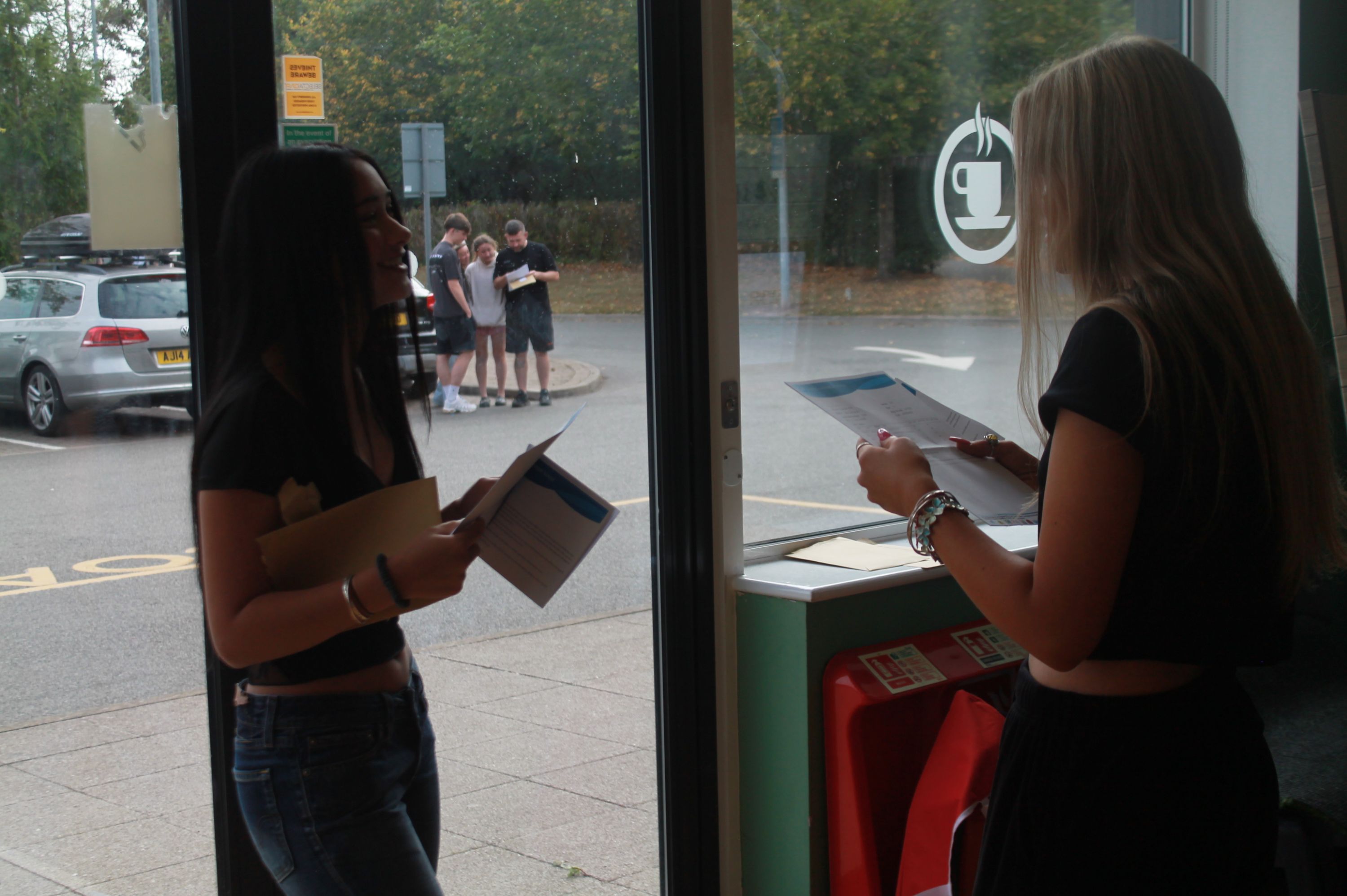 two students opening their GCSE results
