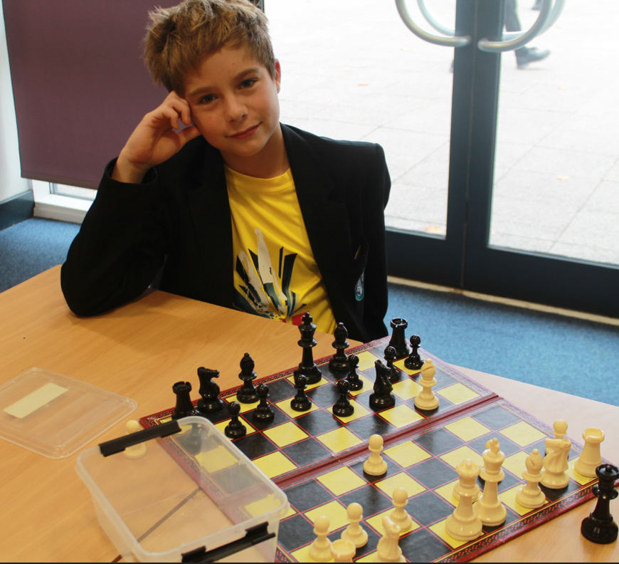 a student playing chess wearing a yellow t shirt