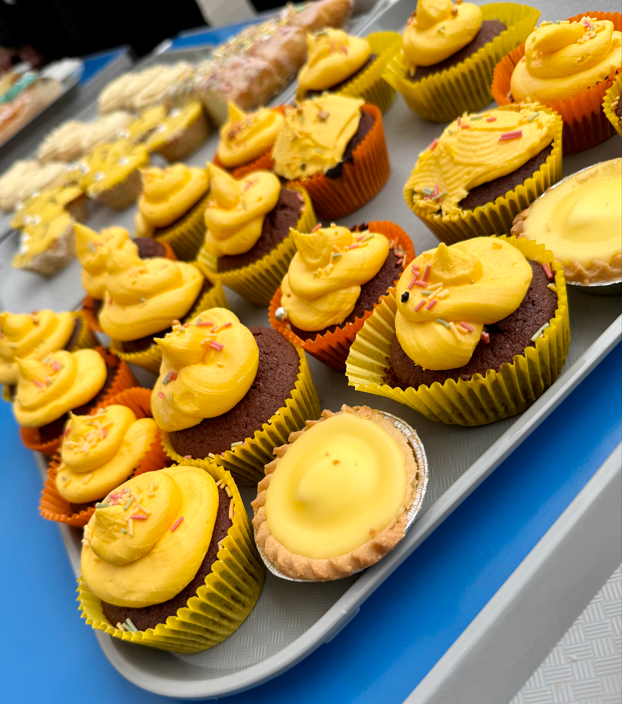 a tray of cakes with yellow icing
