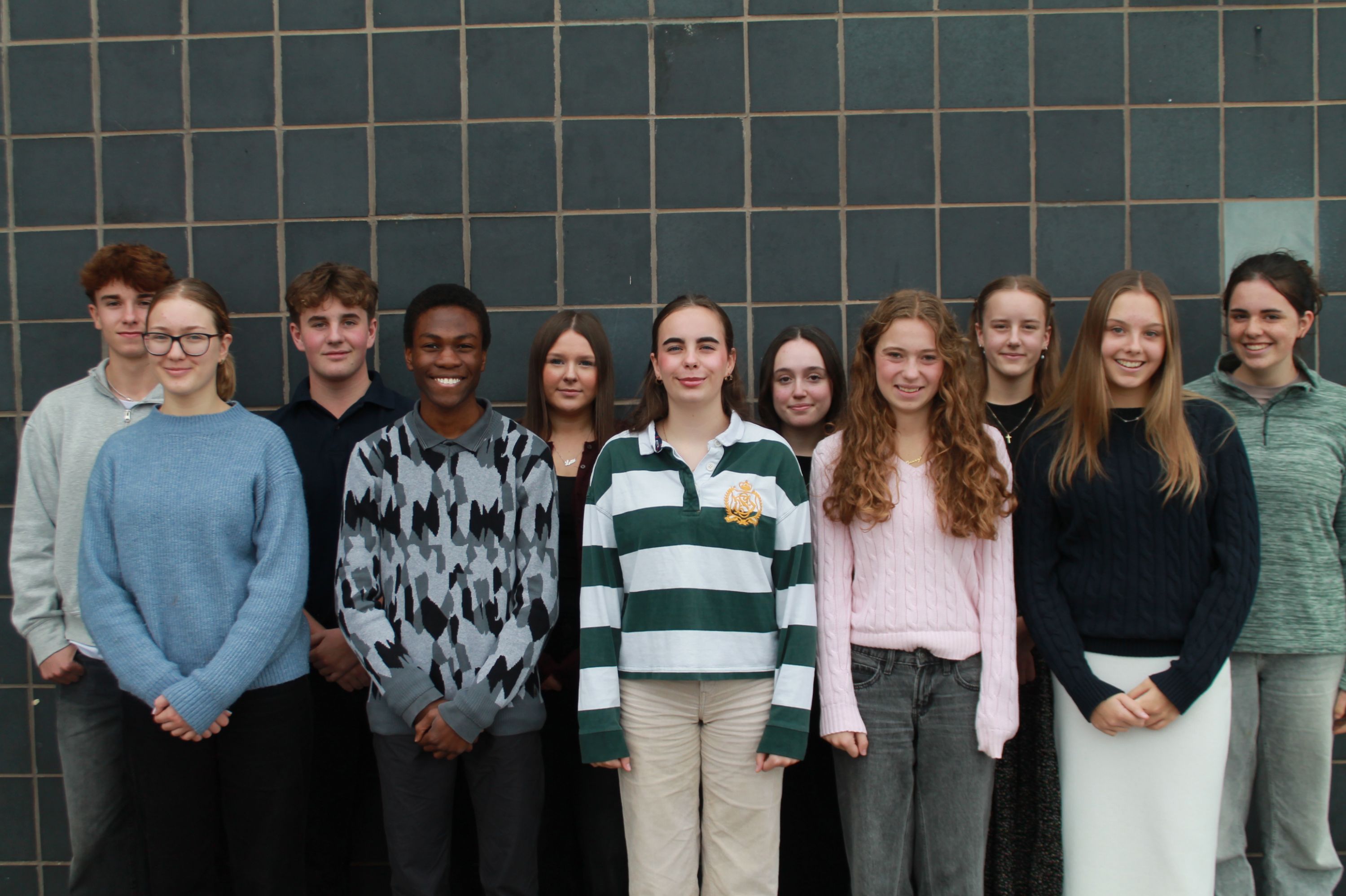 12 students standing together - College Leaders