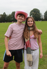 TWO STUDENTS STANDING TOGETHER DRESSED IN PINK